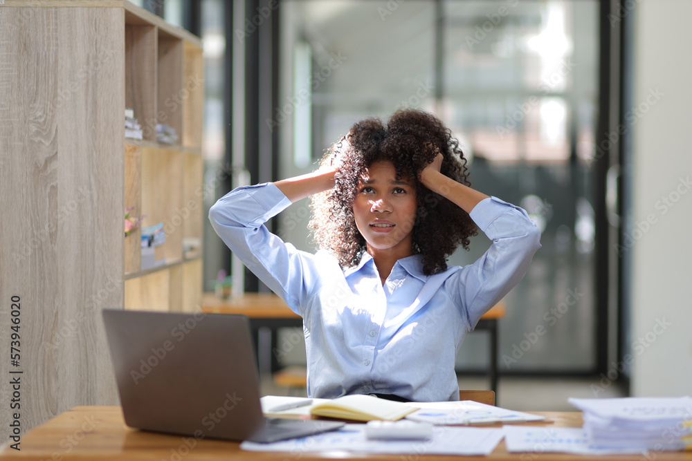 African woman in office stressed and worried about unsuccessfully working on deadlines. Stress and p