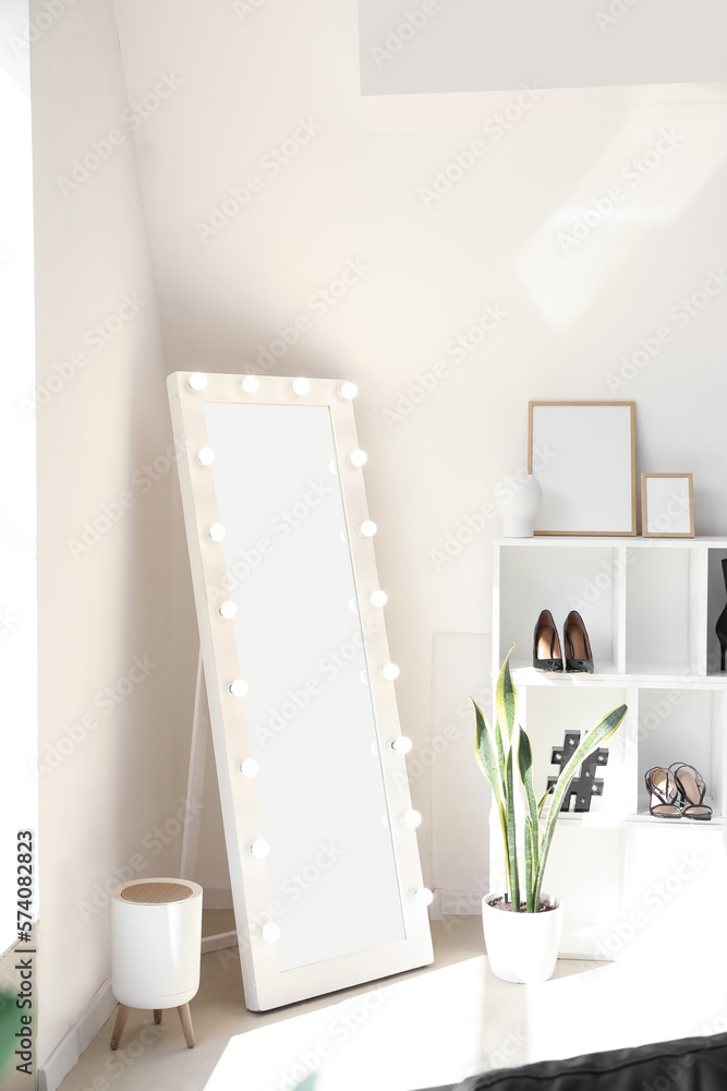 Stylish mirror in interior of light dressing room