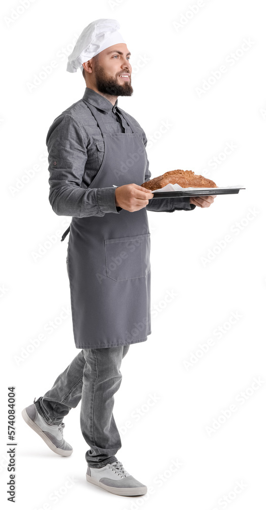 Male baker holding tray with rye bread on white background