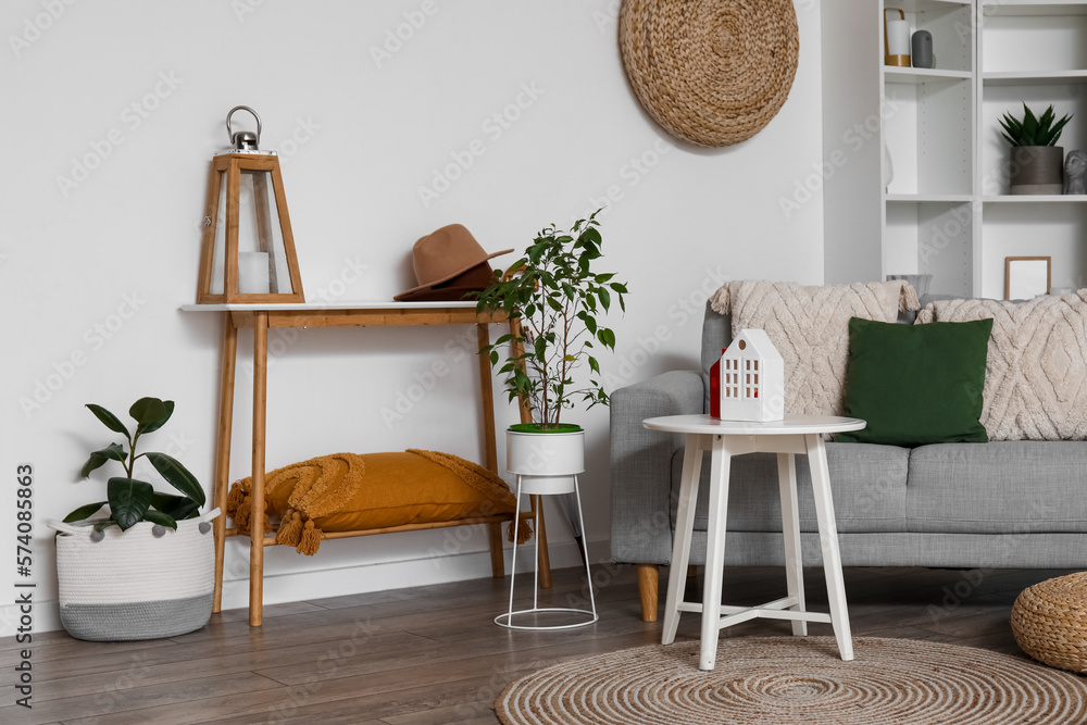 Interior of living room with sofa, tables and house candle holders