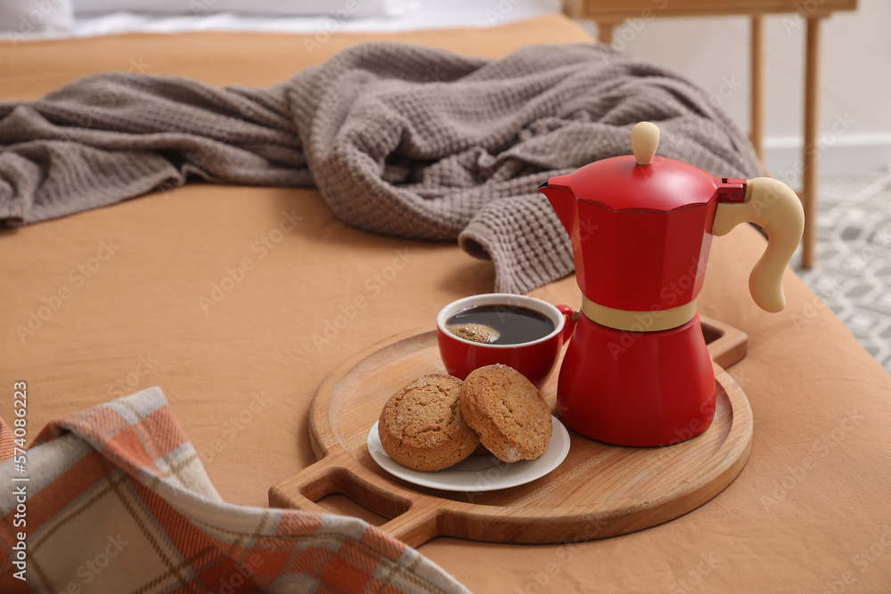 Plate with geyser coffee maker, delicious cookies and cup of espresso on bed