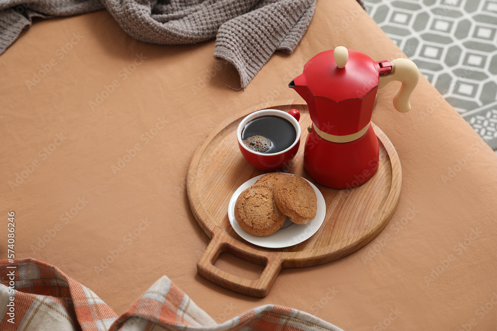 Plate with geyser coffee maker, delicious cookies and cup of espresso on bed