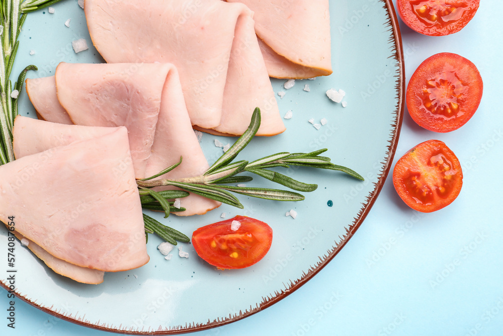 Plate with slices of tasty ham, tomatoes and rosemary on blue background