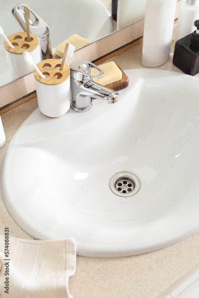 Ceramic sink and bath supplies on table, closeup