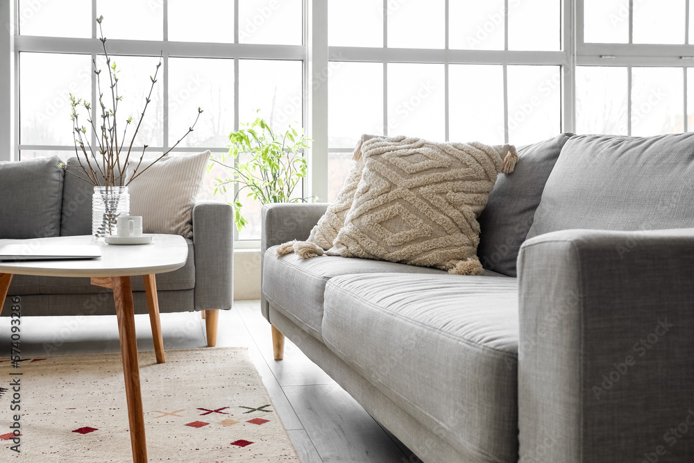 Grey sofas with stylish cushions in light living room