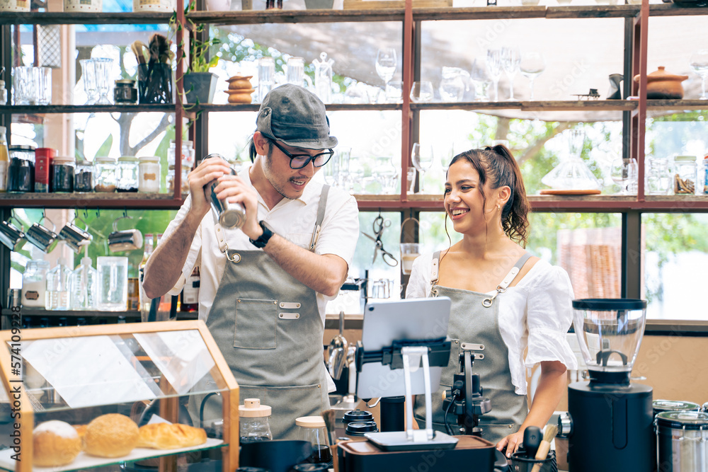 Asian attractive male barista and waitress work in coffeehouse shop. 