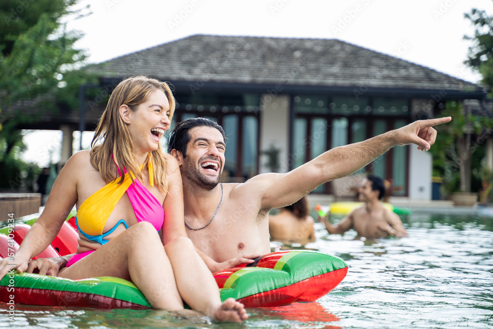 Caucasian young couple spend free time having a pool party together.