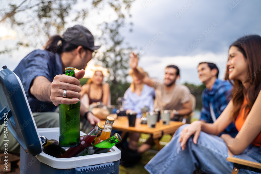 Group of diverse friend having outdoors camping party together in tent. 