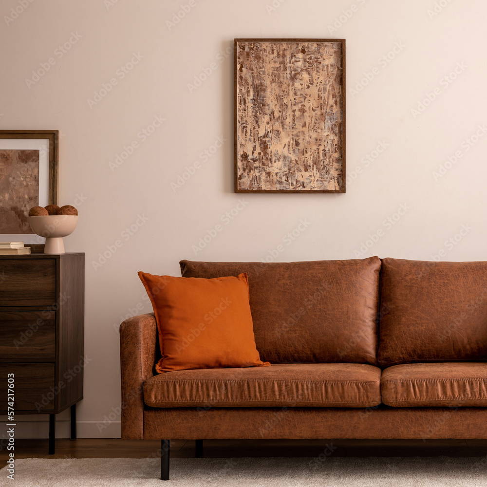 Warm and cozy interior of living room space with brown sofa, beige carpet, lamp, mock up poster fram