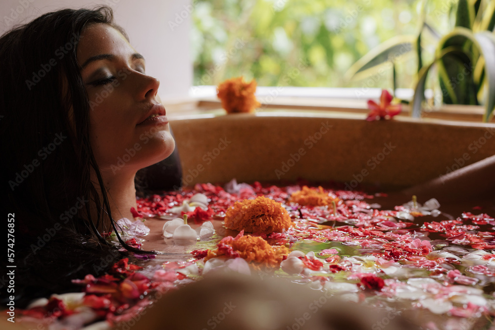 Young woman having flower bath