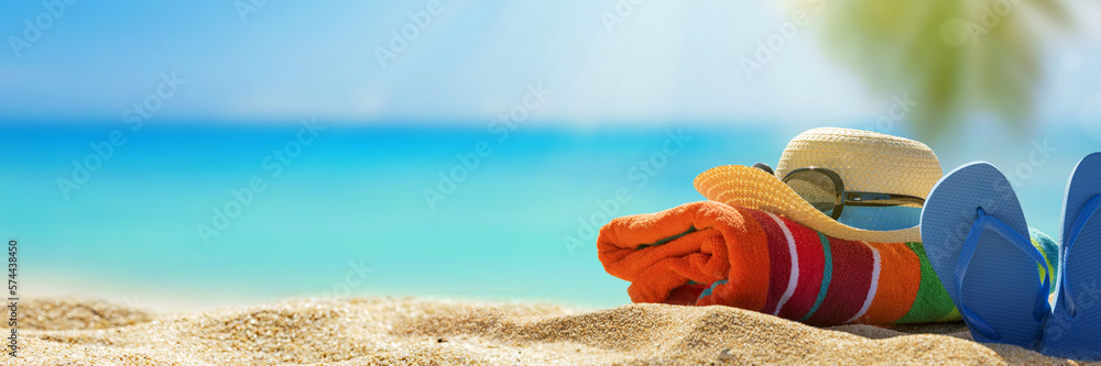 Summer holiday background with flip flops and palm tree on sandy beach