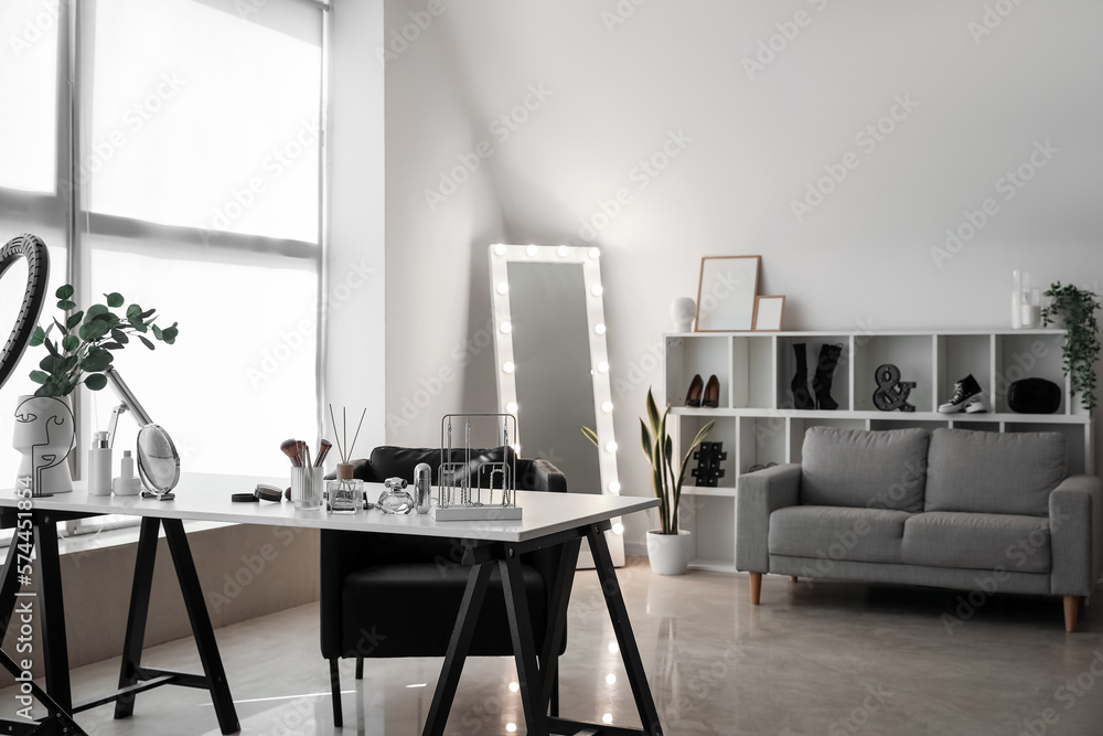 Interior of light makeup room with table, mirror and sofa