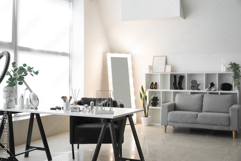 Interior of light makeup room with table, mirror and sofa