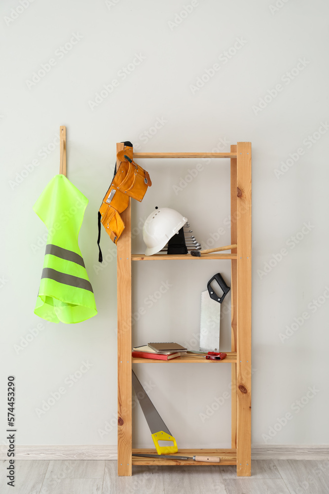 Shelving unit with builders supplies and reflective vest on light wall