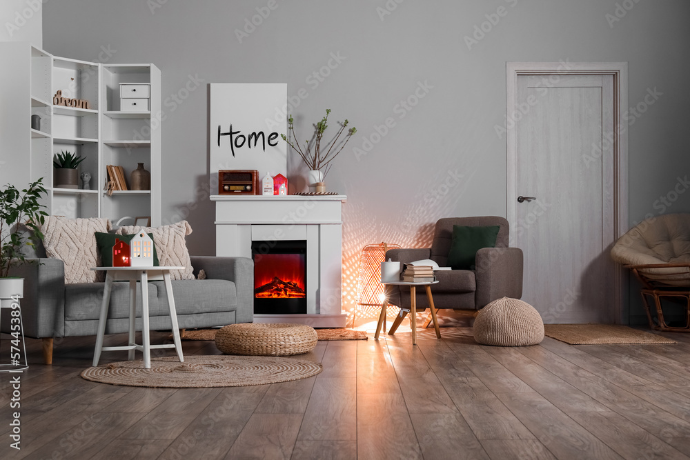 Interior of living room with fireplace, glowing lamp and candle holders