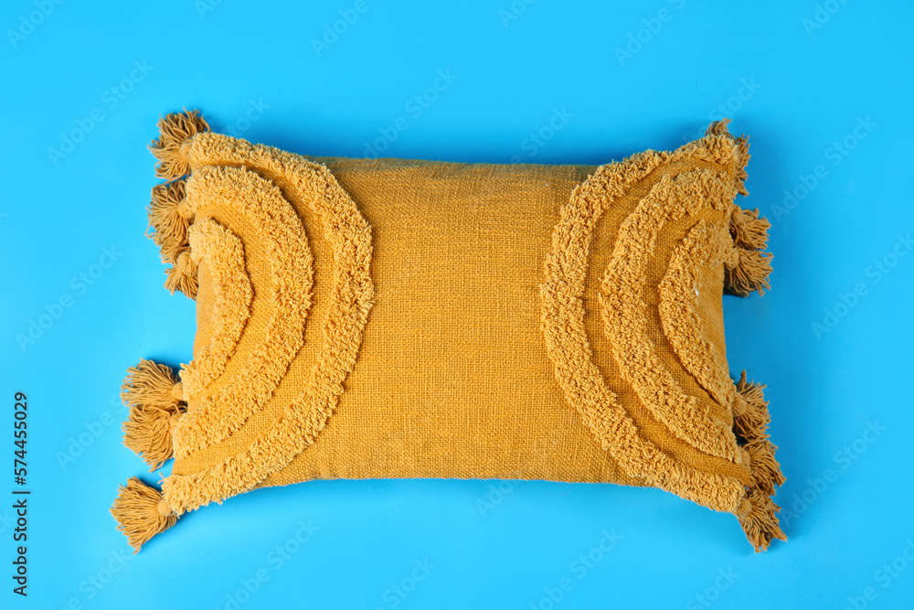 Soft decorative pillow on blue background