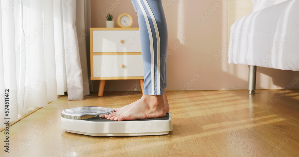 woman measure weight on scale