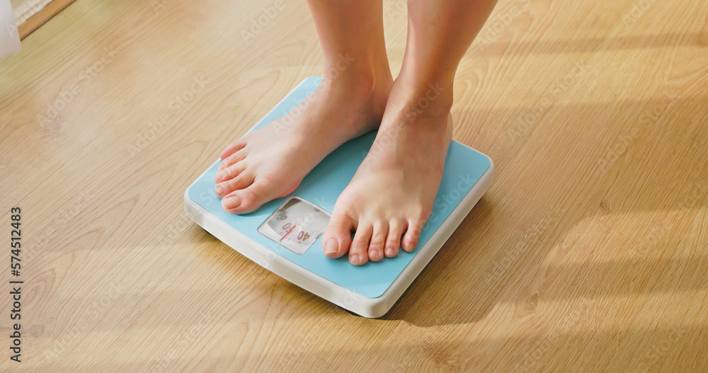 woman measure weight on scale