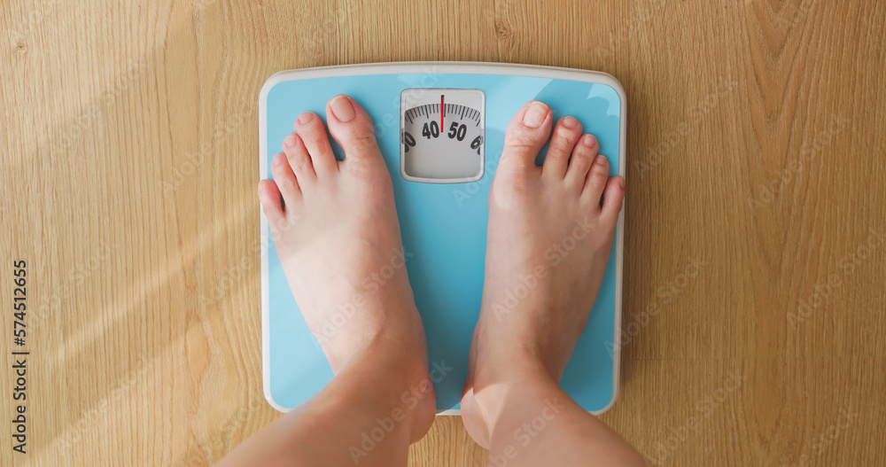 woman measure weight on scale