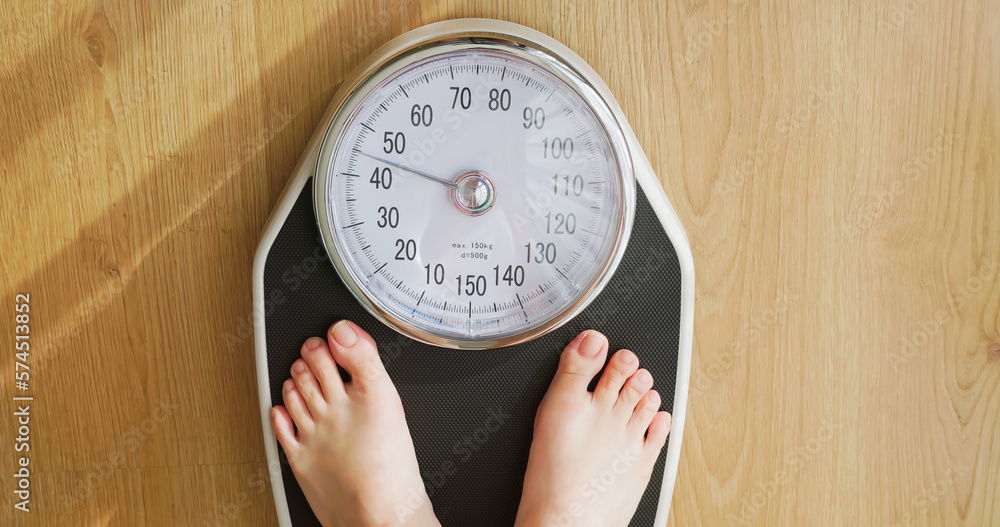 woman measure weight on scale