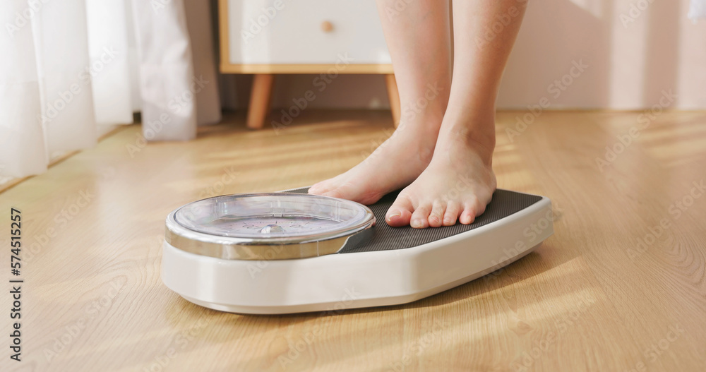 woman measure weight on scale