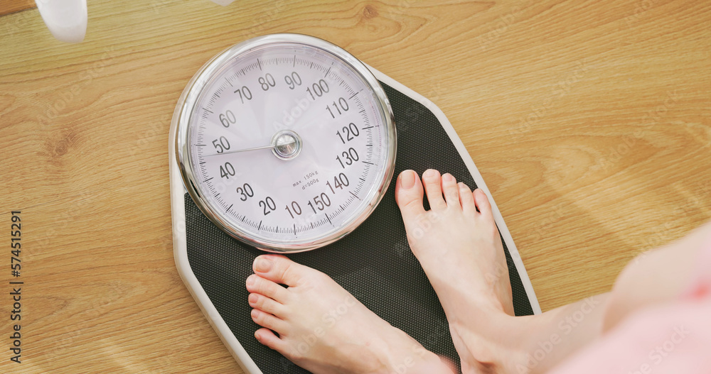 woman measure weight on scale