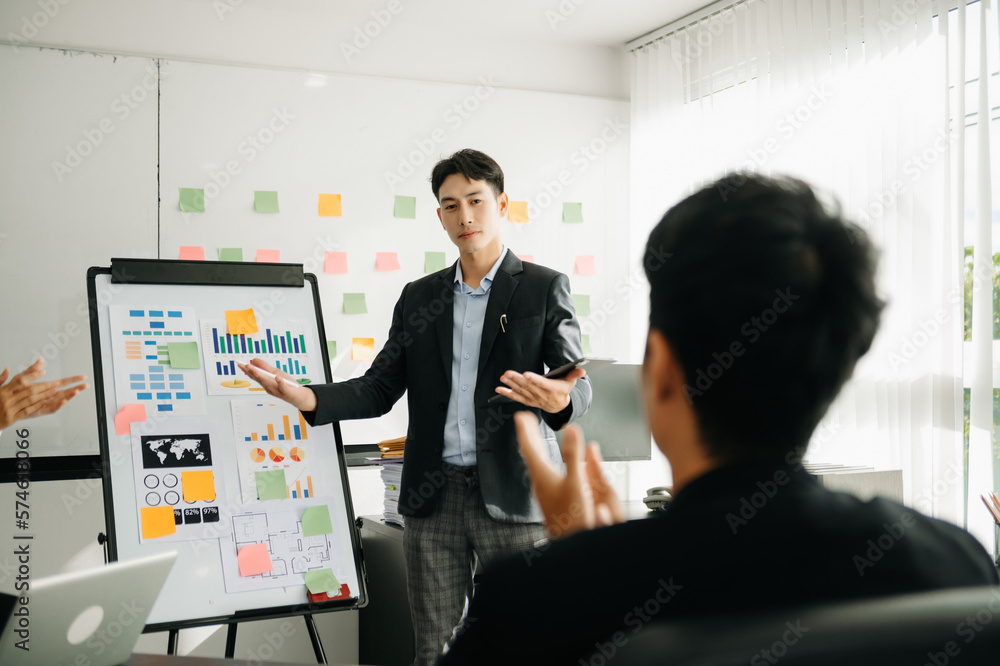 The boss stands near the board with graphs, demonstrates statistics, various personnel attending the