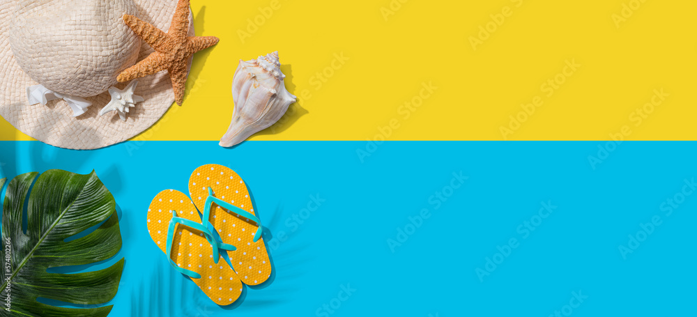 Summer concept with a straw hat, starfish, beach sandals and shell overhead view