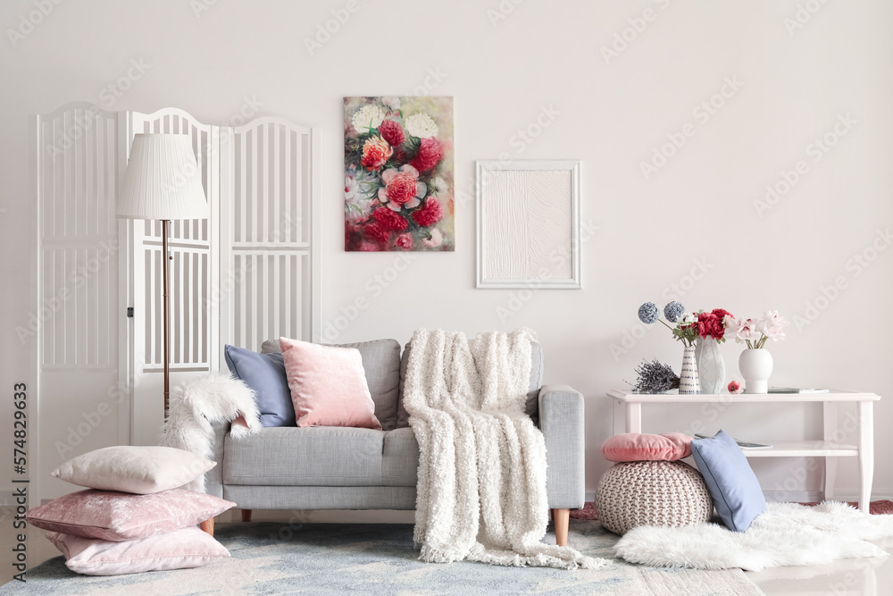 Interior of living room with sofa and flowers in vases