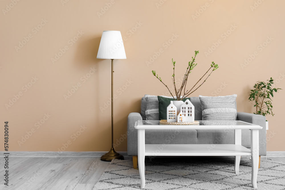 Interior of living room with sofa, table and house candle holders