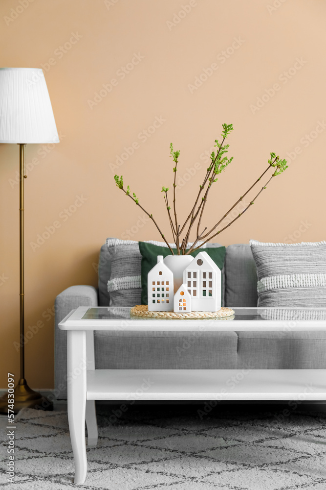 House candle holders and vase with tree branches on table in living room