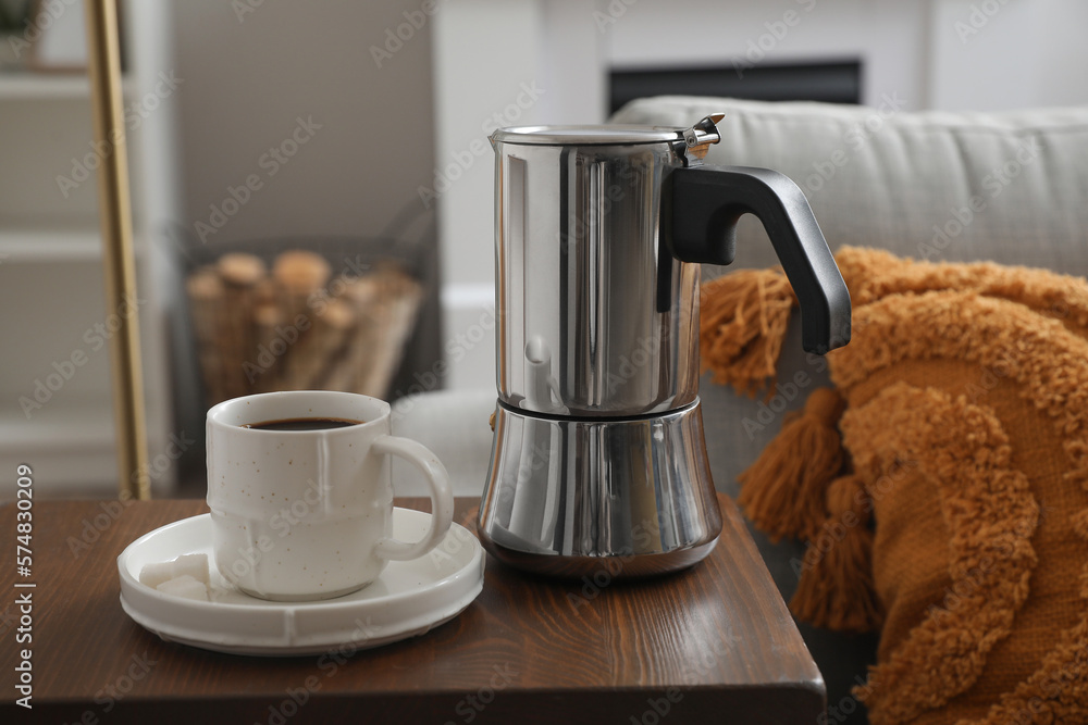 End table with geyser coffee maker and cup of espresso on sofa