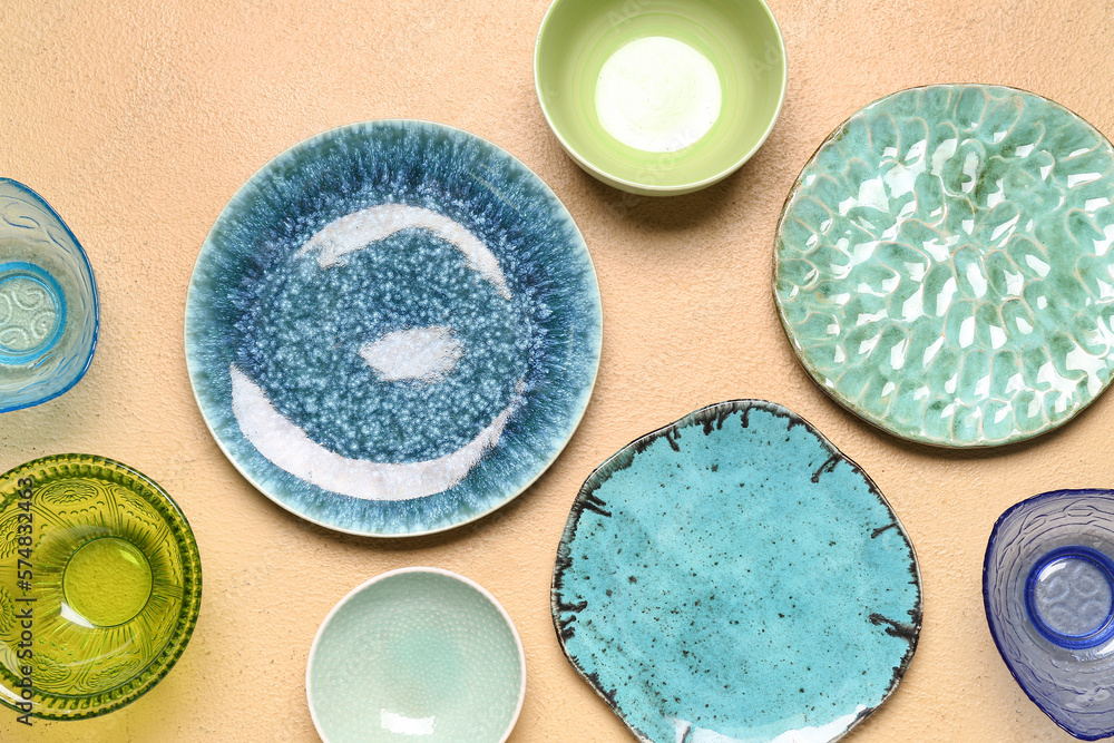 Composition with clean ceramic plates and bowls on beige background