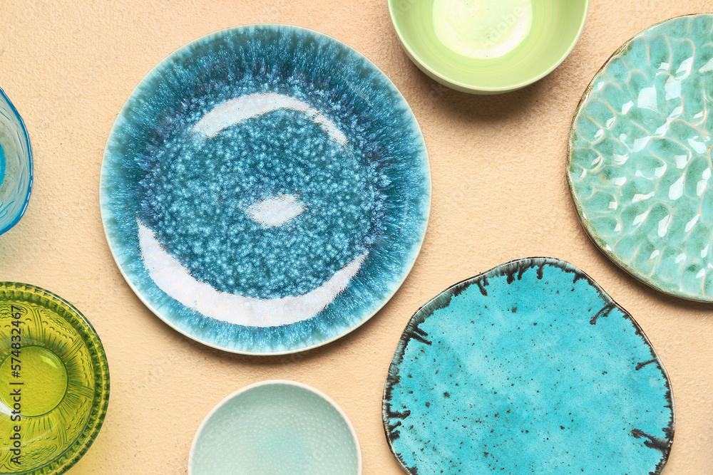 Composition with clean ceramic plates and bowls on beige background