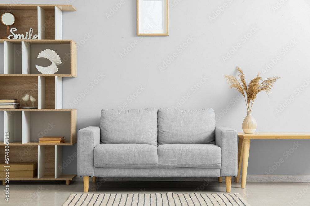 Stylish grey sofa in interior of living room