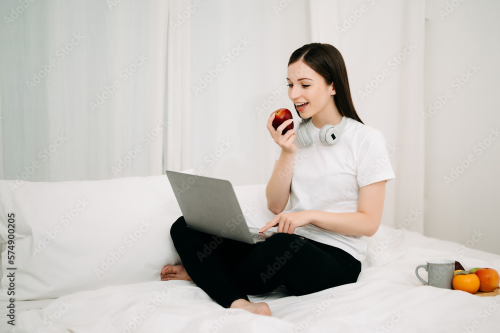 Beautiful woman has woken up on a white bed and holding coffee in the morning at home in morning