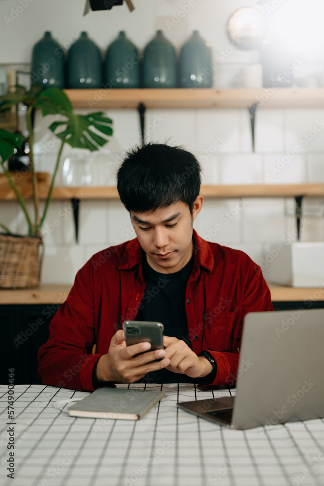 Portrait of young asian man sitting at his desk in the office.