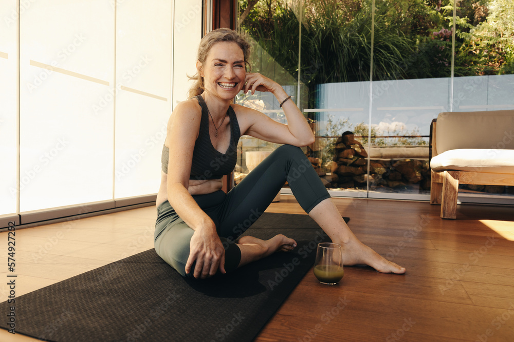 Senior woman smiling at the camera on a yoga mat