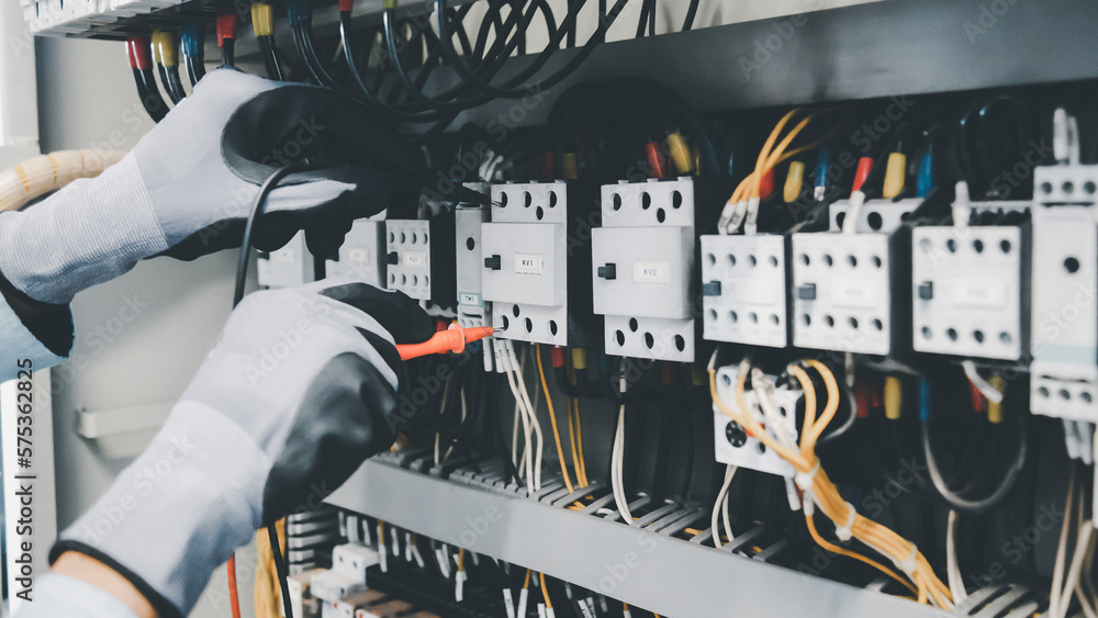 Electrical engineers test electrical installations and wiring on protective relays, measuring them w