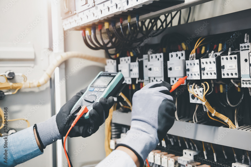 Electrical engineer using digital multi-meter measuring equipment to checking electric current volta