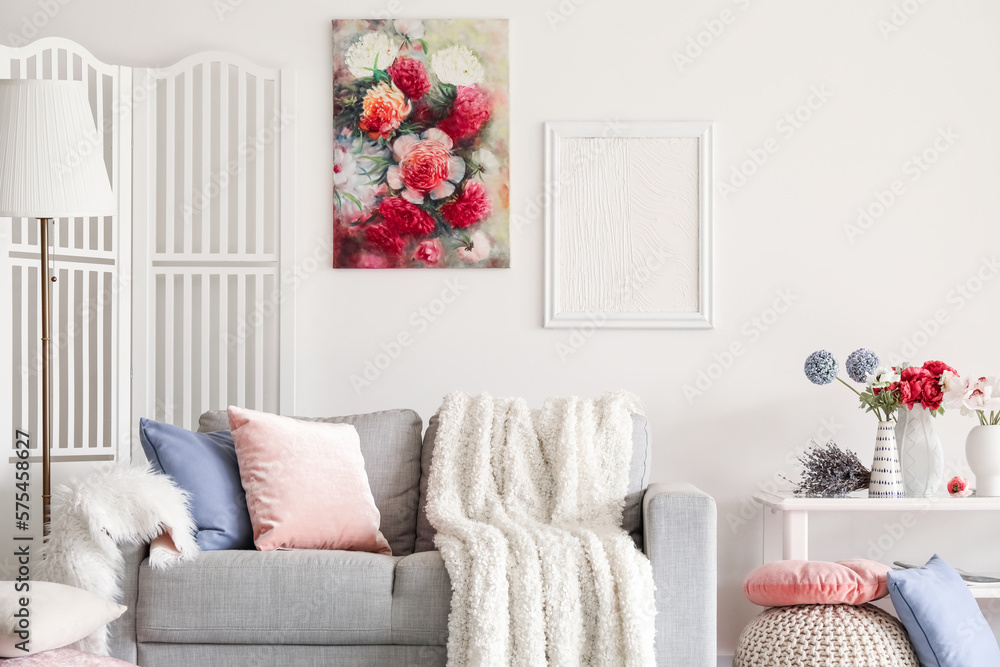 Interior of living room with sofa and flowers in vases