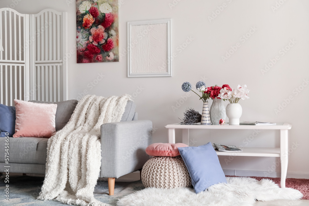 Interior of living room with sofa and flowers in vases