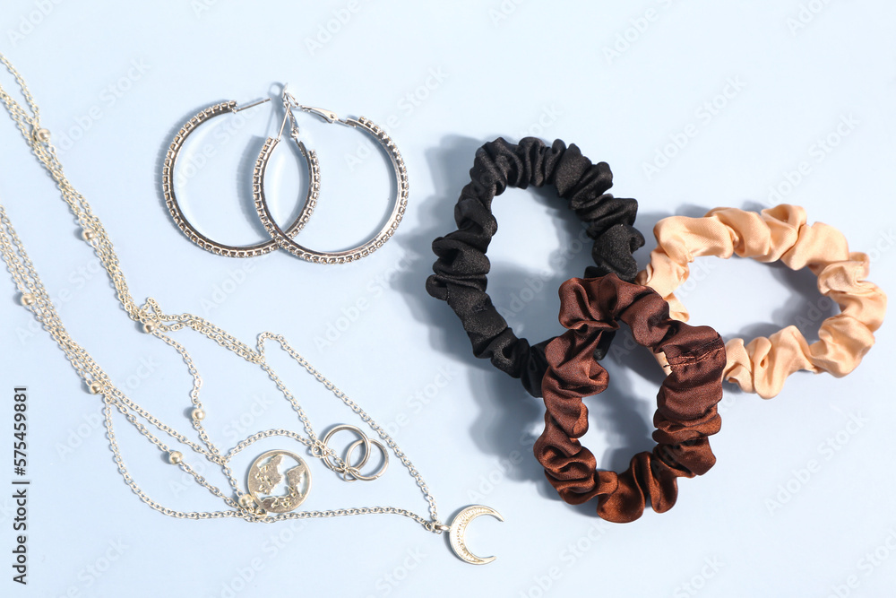 Stylish accessories and scrunchies on color background