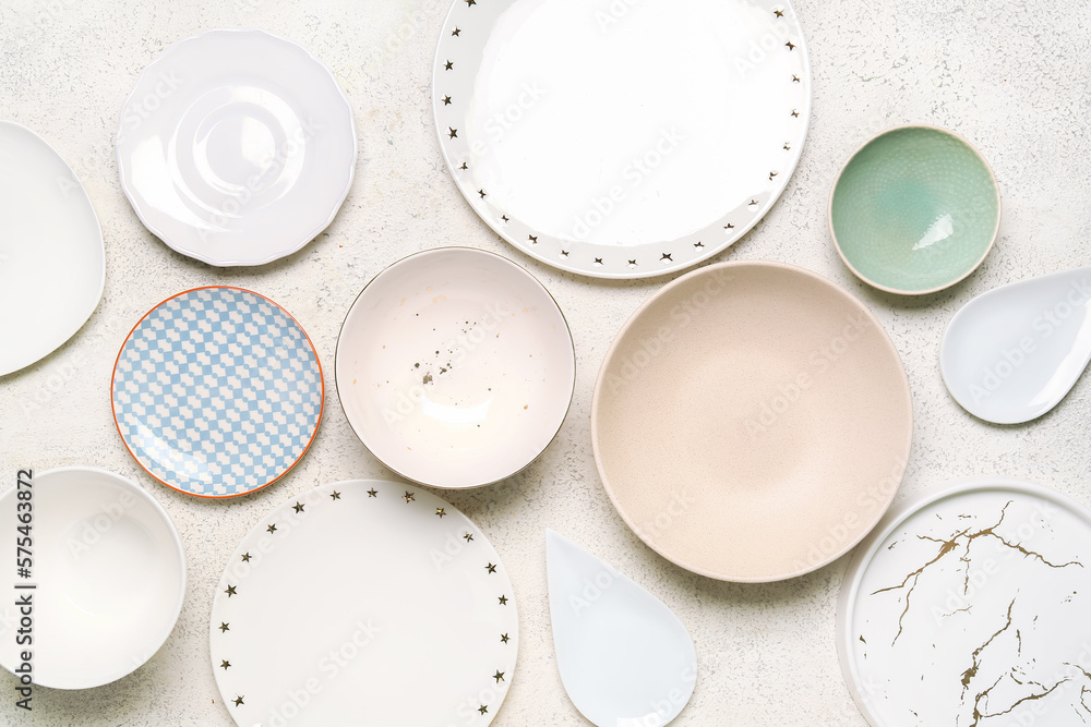 Composition with clean ceramic plates and bowls on white background