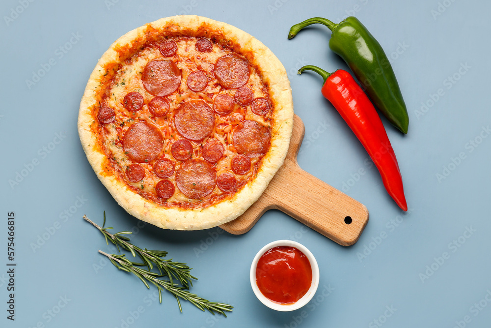 Board with delicious pepperoni pizza and jalapeno peppers on blue background