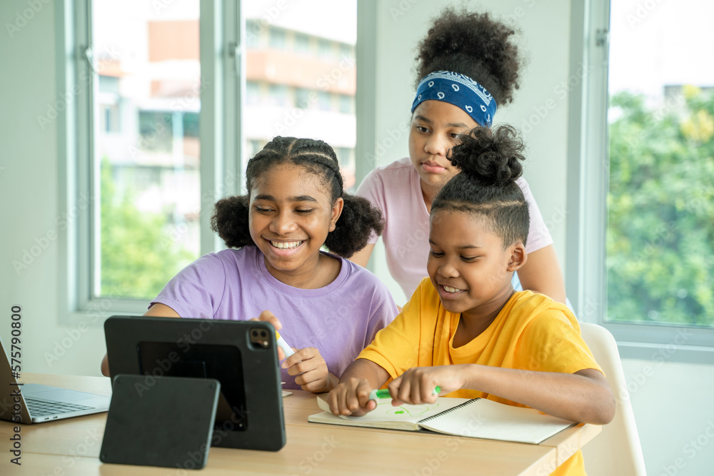 African American junior school kid girl student using digital tablet computer education program app 