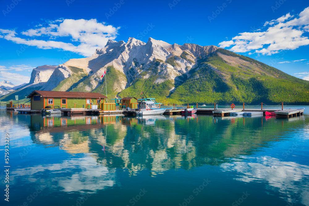 Mountain landscape at the day time. Boats near the pier. Lake and forest in a mountain valley. Natur