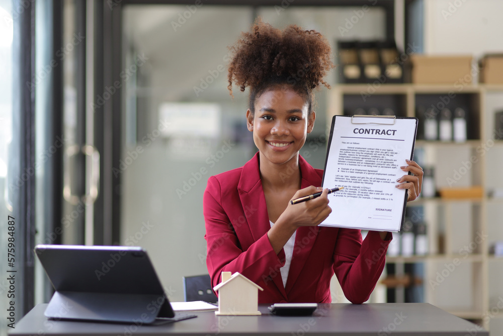 African businesswoman, real estate agent presenting residential building and house sale contract to 