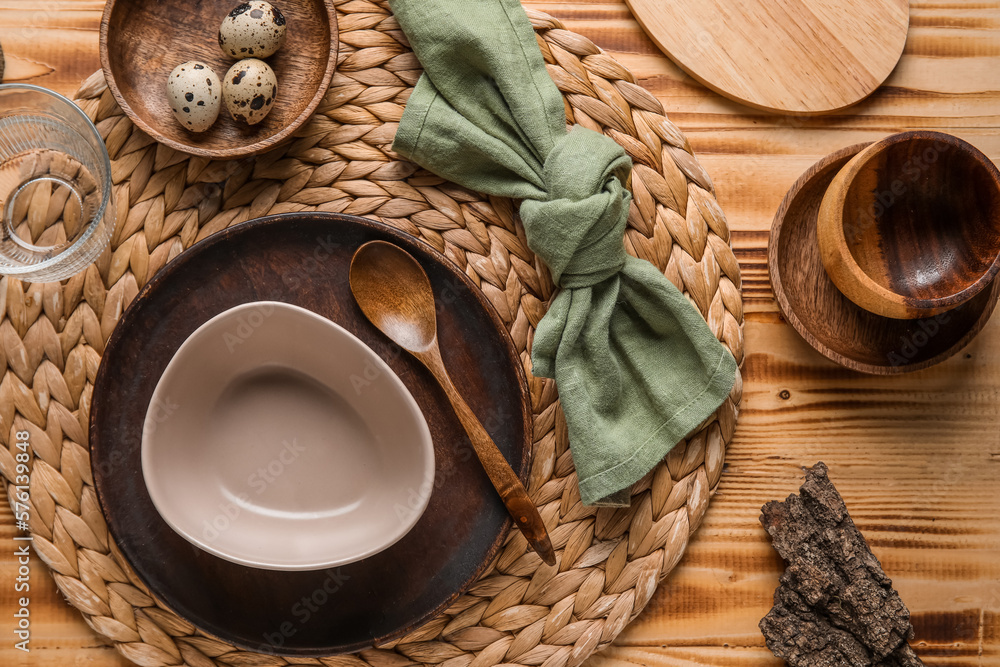 Beautiful table setting with plates, bowl and quail eggs on wooden background