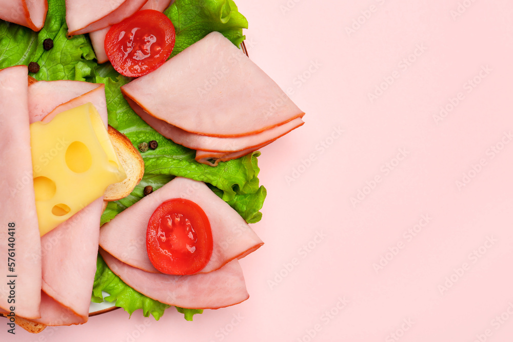 Plate with tasty slices of ham, cheese, lettuce and tomatoes on pink background